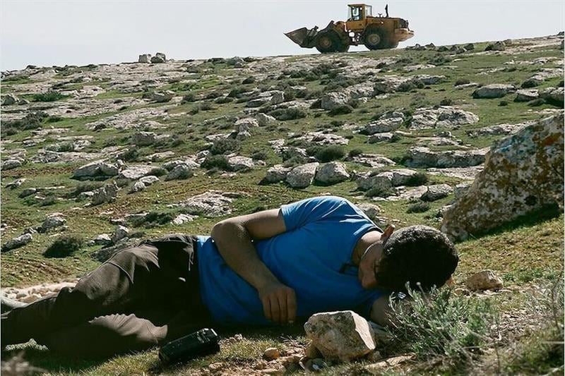 El palestino Basel Adra con topadora israelí de fondo. 