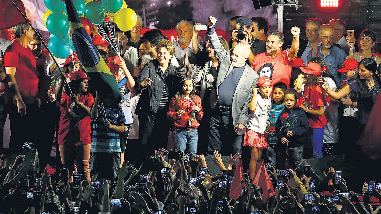 Lula saluda rodeado de seguidores durante un acto de campaña en Curitiba.