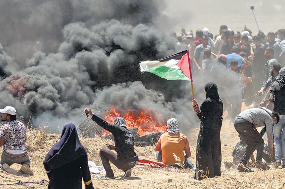 Un mujer sostiene una bandera palestina durante una protesta en la frontera entre Gaza e Israel.
