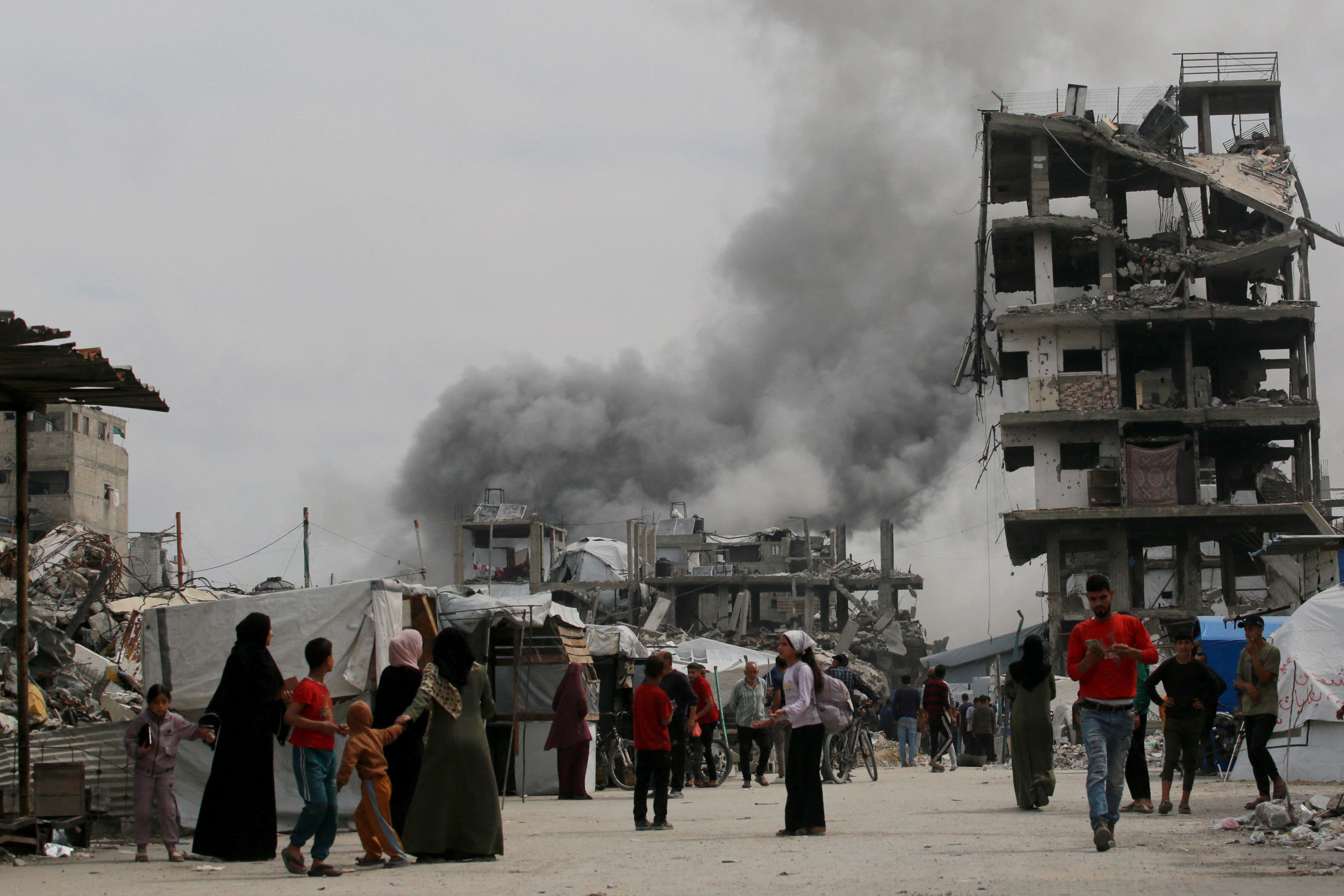 Palestinos corren a refugiarse cuando un ataque israelí impacta una casa en Yabalia, en el norte de Gaza