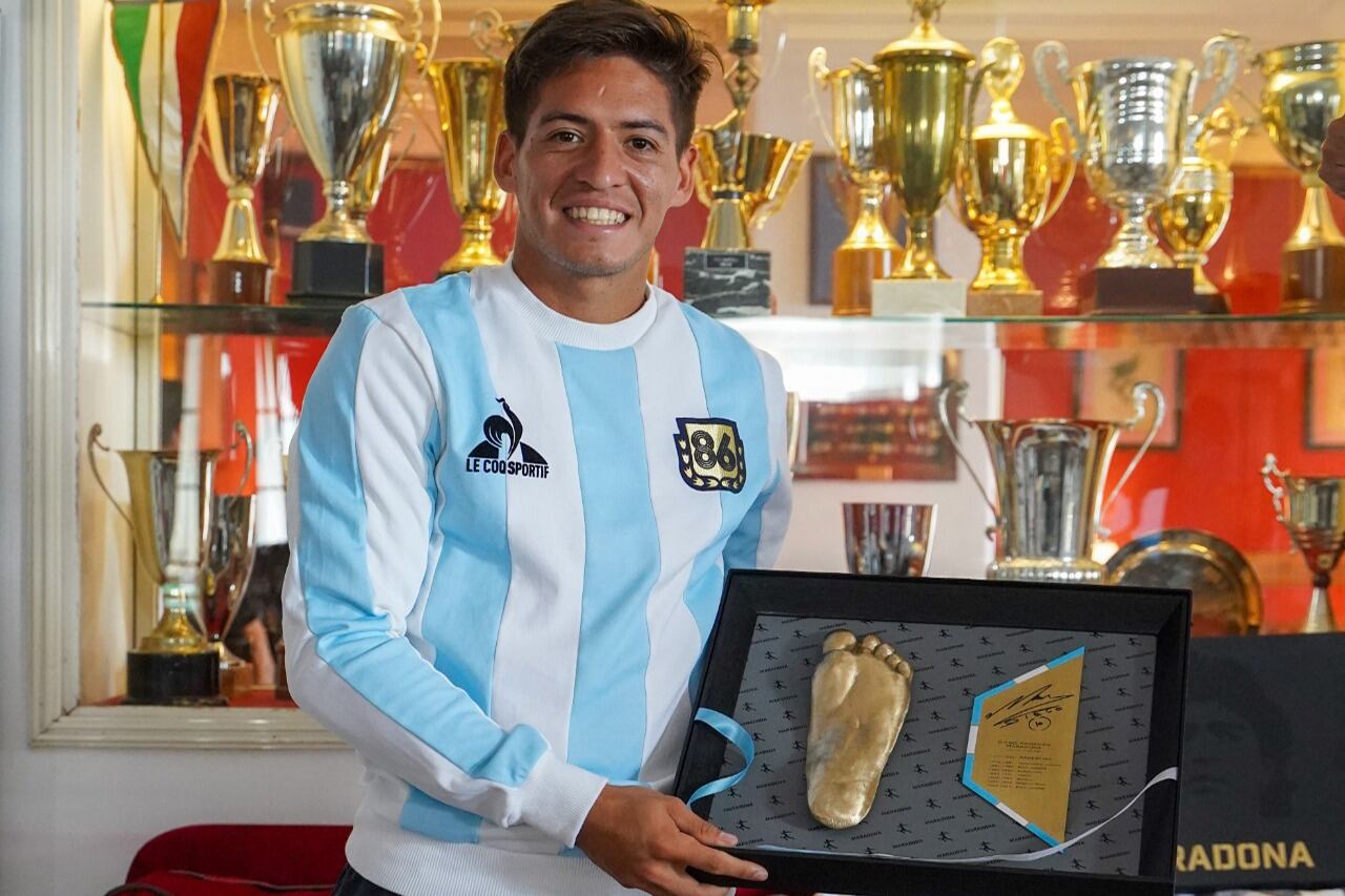 Báez posa con la réplica del pie izquierdo de Diego.