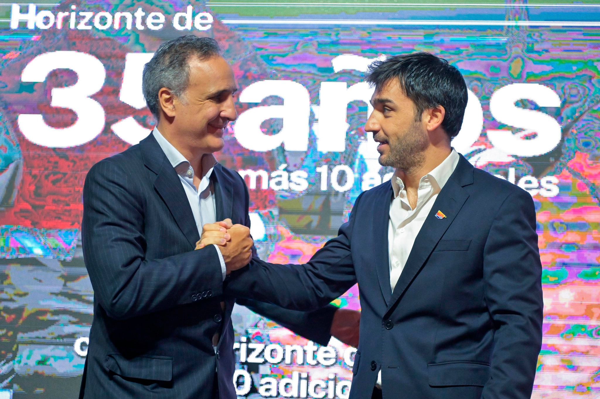 Ignacio Torres (gobernador de Chubut) y Marcos Bulgheroni (CEO de PAE) estrechan las manos luego del anuncio