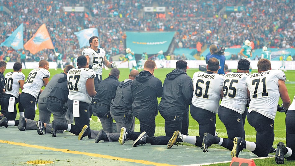 Deportistas de la NFL se arrodillan en el campo de juego durante la entonación del himno.