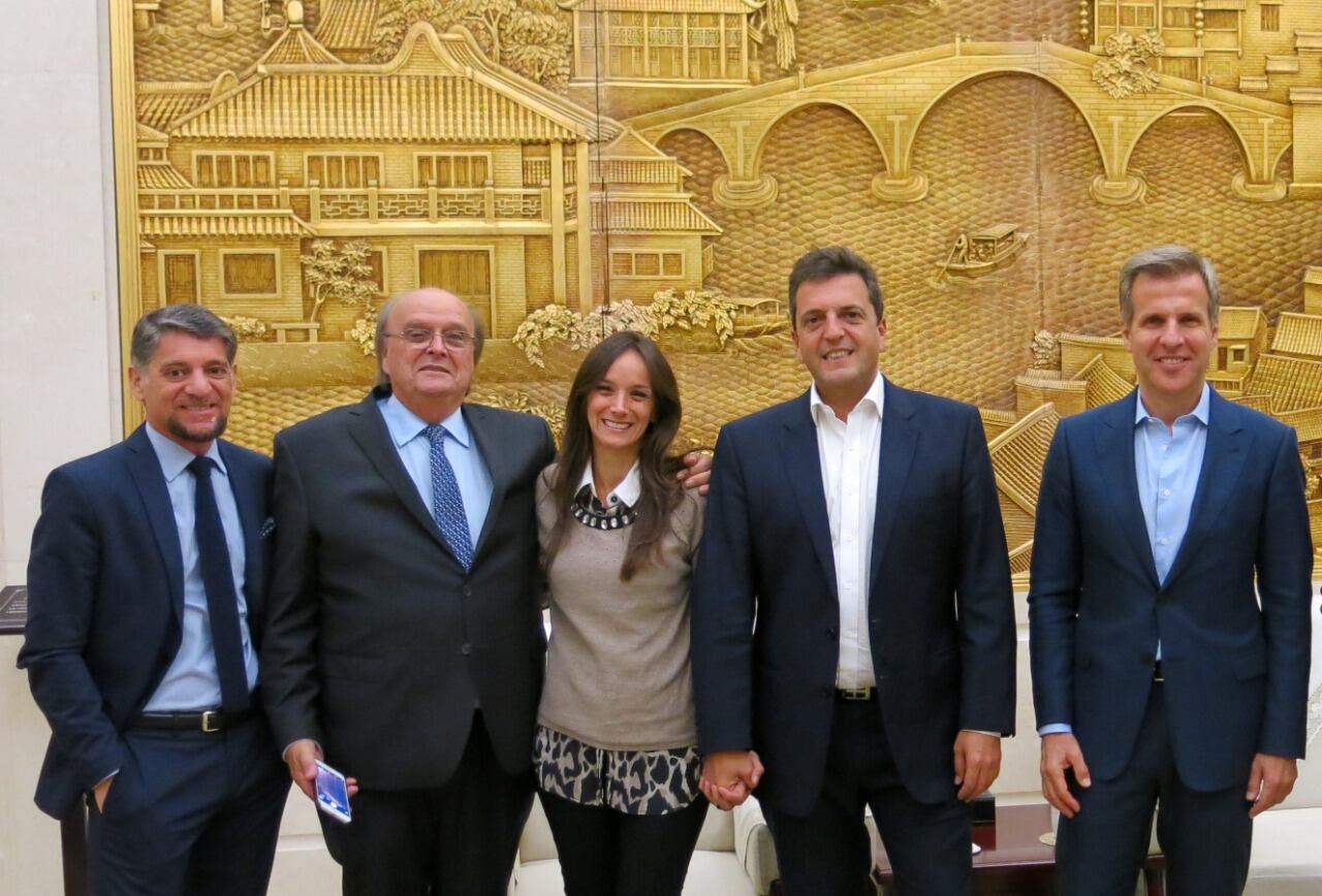 Sergio Massa, Malena Galmarini, José De Mendiguren, Martín Redrado y Gustavo Martínez Pandiani sonríen ante el Gran Mural del Pueblo en Beijing, durante una gira de 2017.