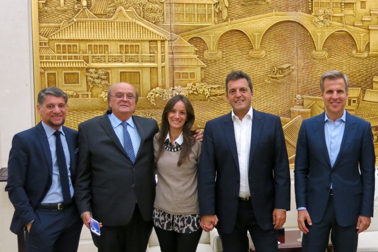 Sergio Massa, Malena Galmarini, José De Mendiguren, Martín Redrado y Gustavo Martínez Pandiani sonríen ante el Gran Mural del Pueblo en Beijing, durante una gira de 2017.