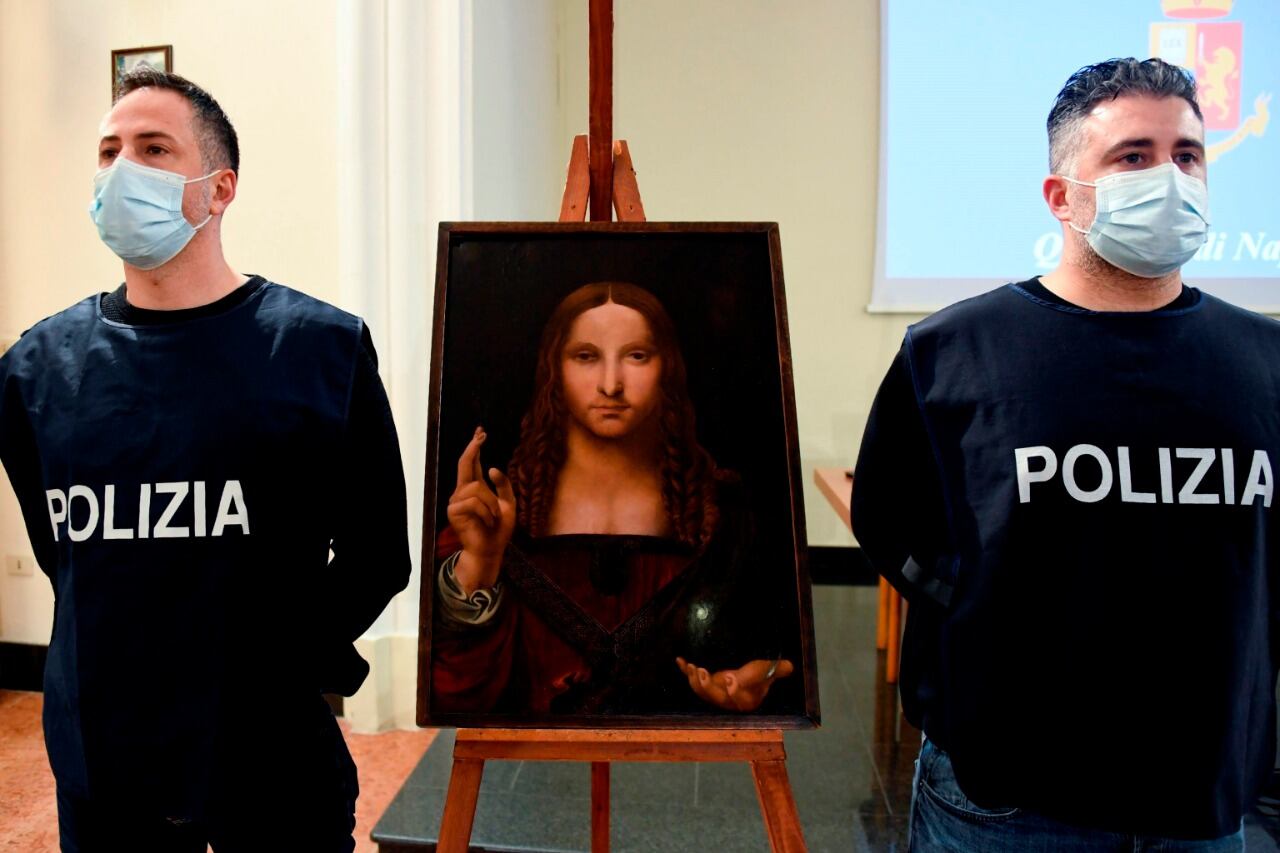 Oficiales de la policía italiana junto a la pintura recuperada.