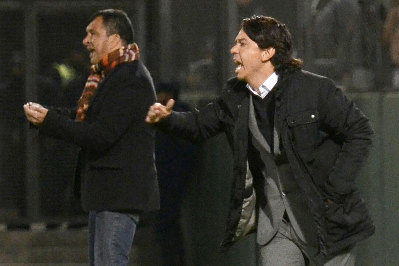 Pelo largo y mucho abrigo para aquel Gallardo debutante de 2014. Detrás, el Cabezón Marini, DT de ese Ferro.