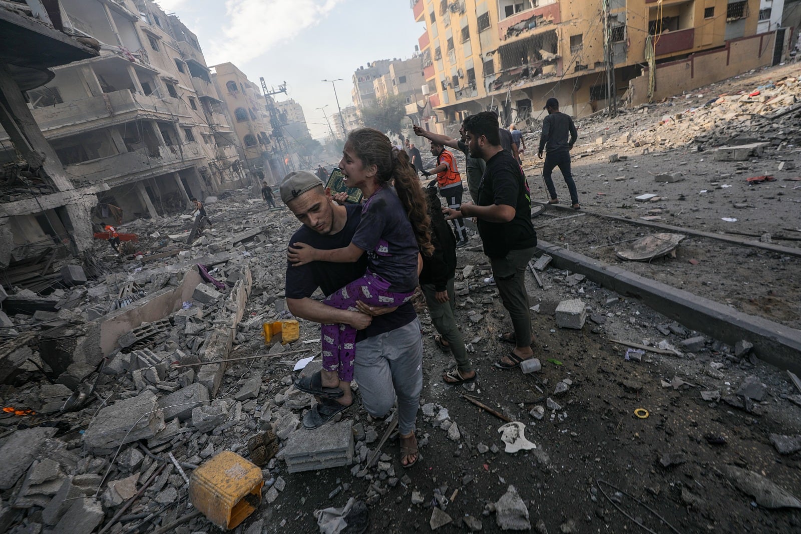 Un hombre lleva en brazos a una niña herida tras un bombardeo en Gaza.