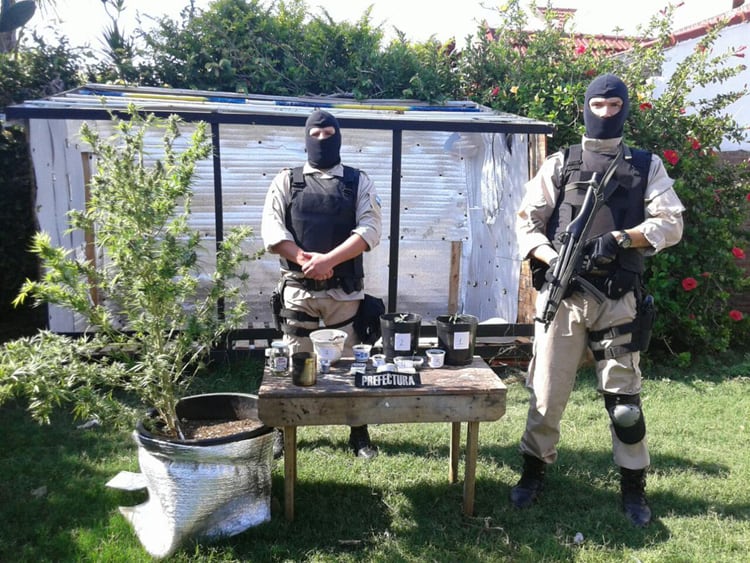 Efectivos encapuchados vigilan el material secuestrado.