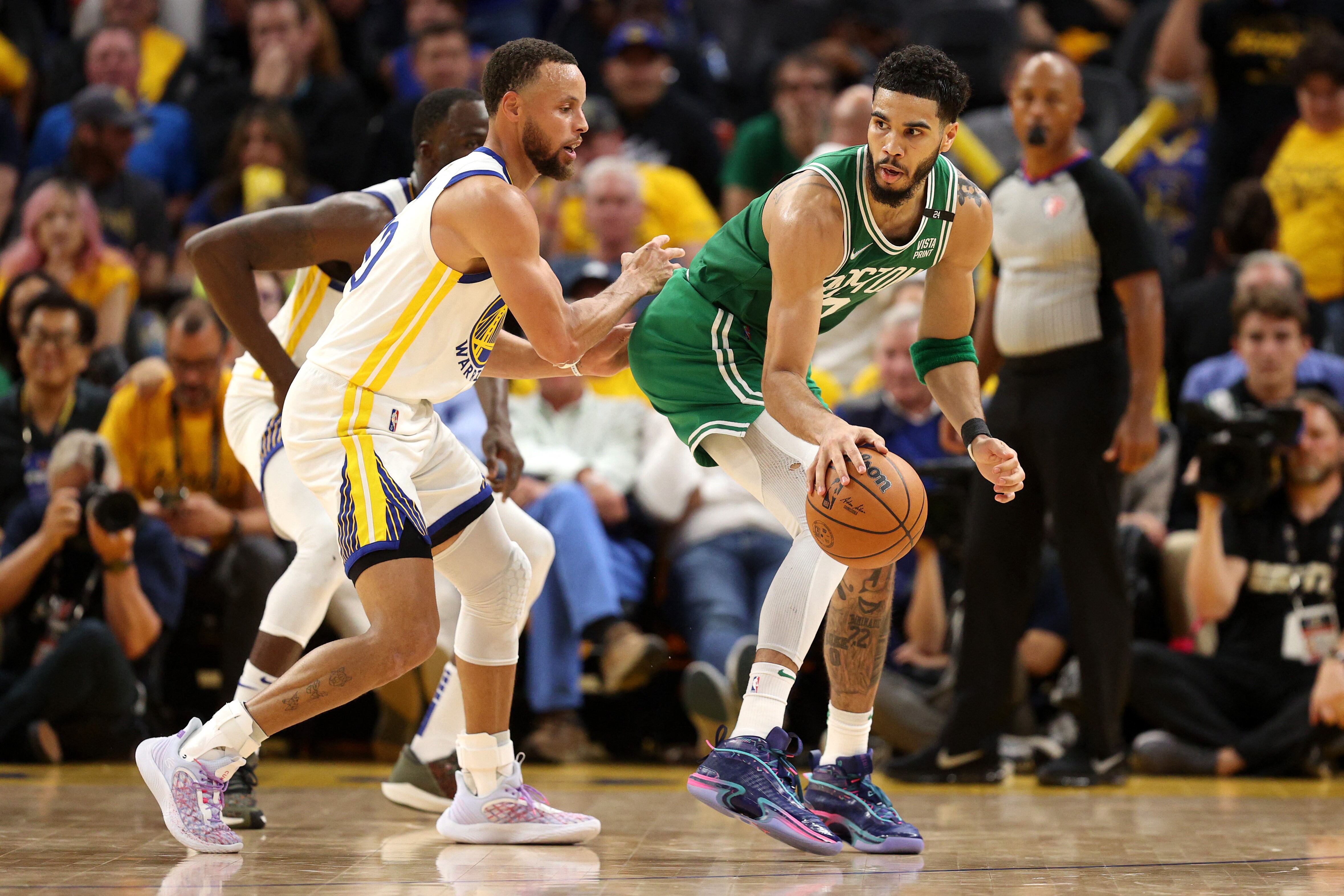 Jayson Tatum, que no tuvo su mejor noche, cuida la pelota ante Stephen Curry.