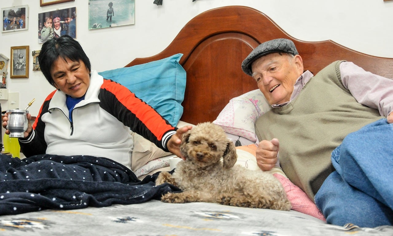 Milagro Sala, su esposo Noro y Bichi, el perro caniche, que se acomoda entre los dos y celebra cada visita con ladridos.