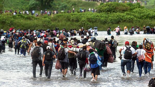 Migrantes salvadoreños cruzan el río Suchiate para ingresar a México desde Guatemala para unirse a la caravana.