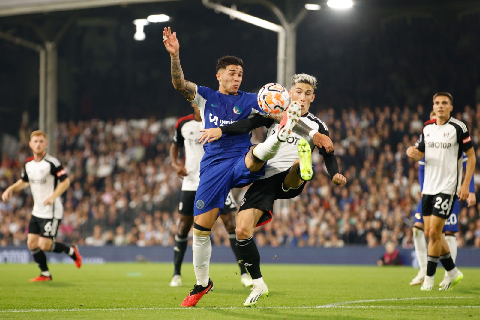 Enzo Fernández en acción y rodeado de casacas blancas