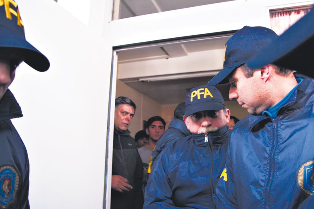 Uno de los gendarmes entra tapando su rostro al juzgado federal de Esquel.