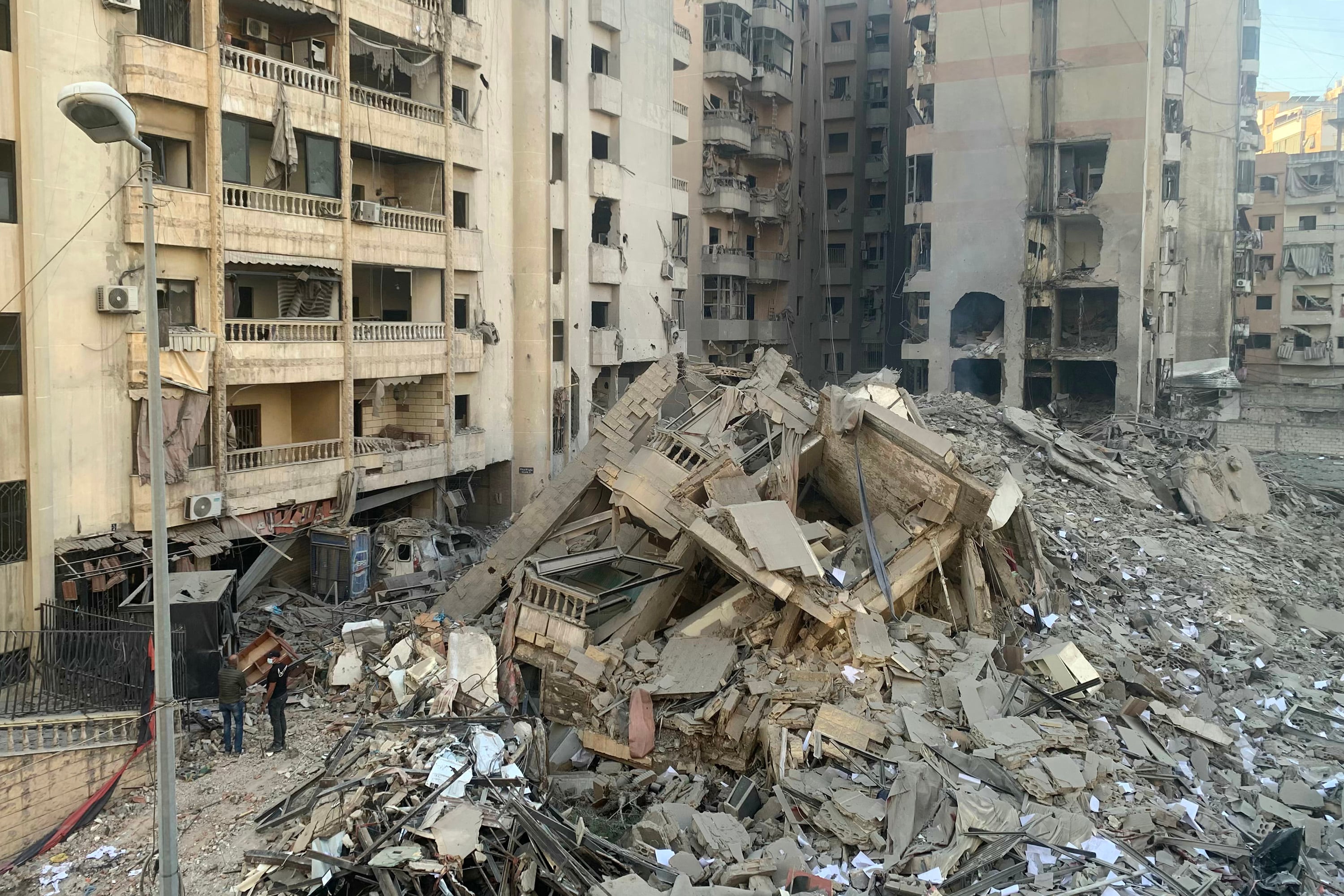 Dos personas observan un edificio derrumbado por un bombardeo israelí entre la noche del jueves y la madrugada del viernes en el sur de Beirut. 