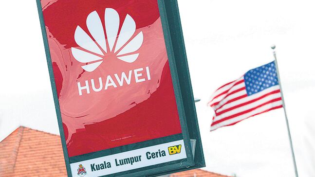 El logo de Huawei desplegado frente a la bandera estadounidense en Kuala Lumpur, Malasia.