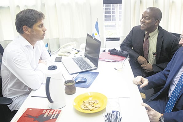 Kicillof recibió en su despacho a Cardarelli y Alleyne. Sobre la mesa, un ejemplar de Por qué la austeridad mata, mate y bizcochitos.