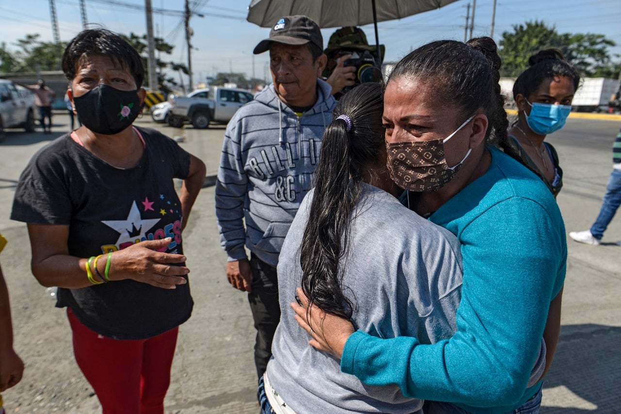 Familiars de detenidos se abrazan después del motín en la entrada a la cárcel de Guayaquil. 