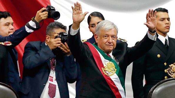 López Obrador saluda y festeja al término de su ceremonia de investidura en la Cámara de Diputados de la capital mexicana.