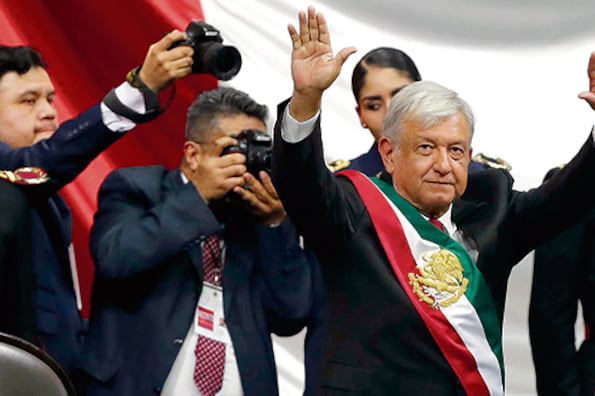 López Obrador saluda y festeja al término de su ceremonia de investidura en la Cámara de Diputados de la capital mexicana.