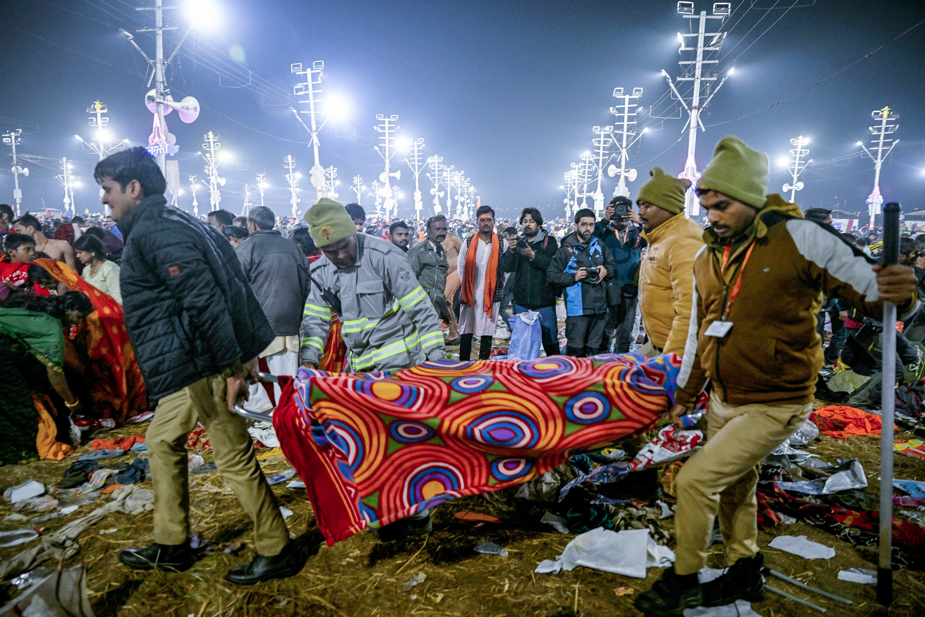 Agentes de policía llevan en camilla a una víctima de la estampida durante el festival Maha Kumbh Mela en Prayagraj.