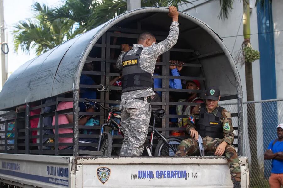 Guardias vigilan a haitianos detenidos en redadas de autoridades migratorias (República Dominicana). Imagen: Orlando Barría