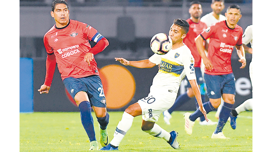 Zenteno disputa la pelota con Reynoso. Boca apenas arañó un 0-0 en Bolivia.