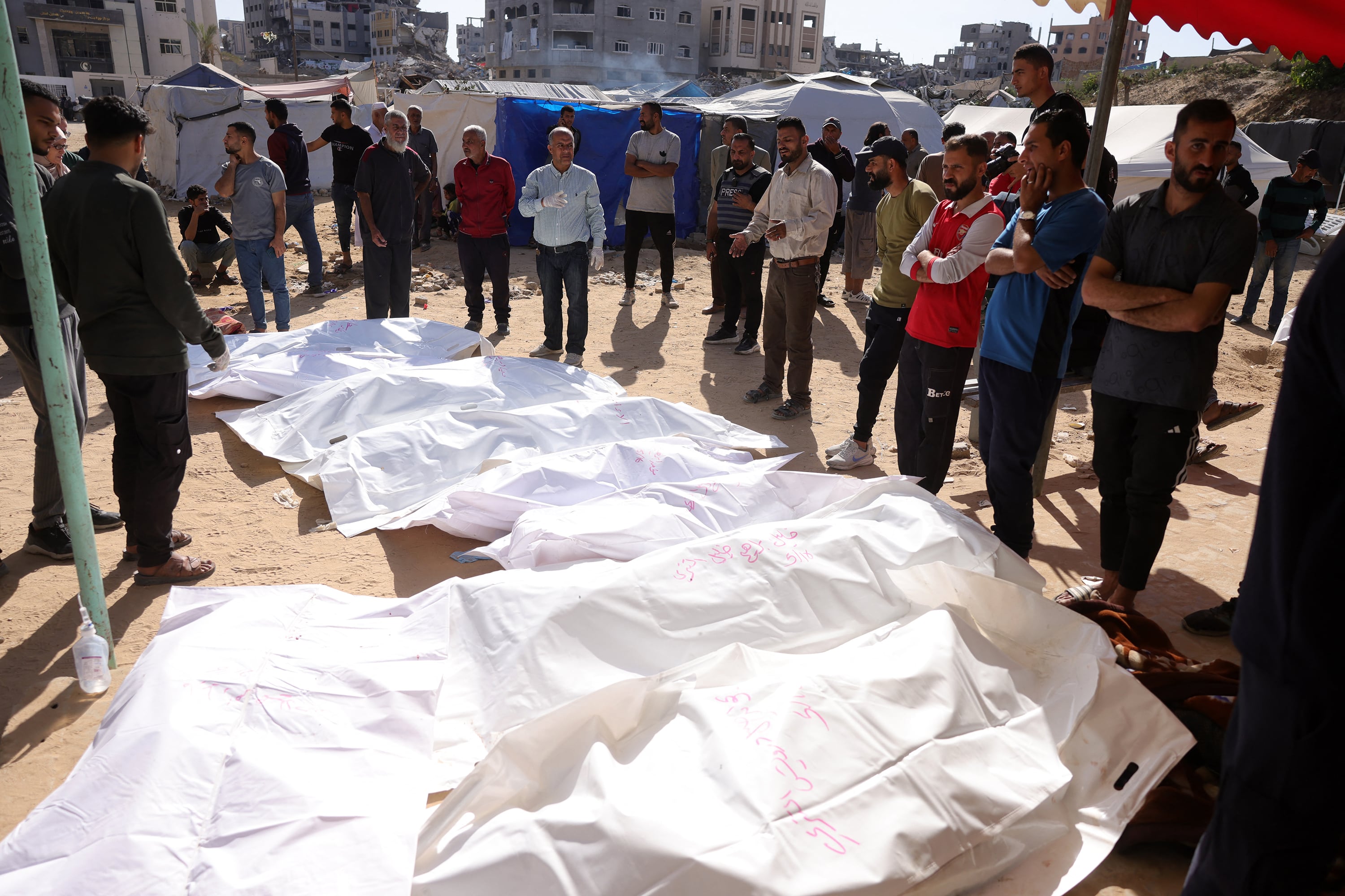 Un grupo de personas rodea los cuerpos de palestinos muertos en un ataque israelí frente al hospital de Beit Lahia