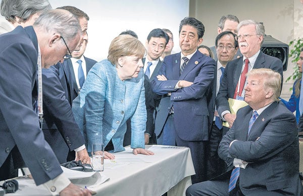 Trump sentado, los demás líderes del G7 parados y una Merkel desafiante que parece increparlo en Charlevoix.