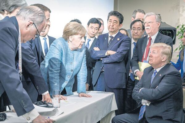 Trump sentado, los demás líderes del G7 parados y una Merkel desafiante que parece increparlo en Charlevoix.