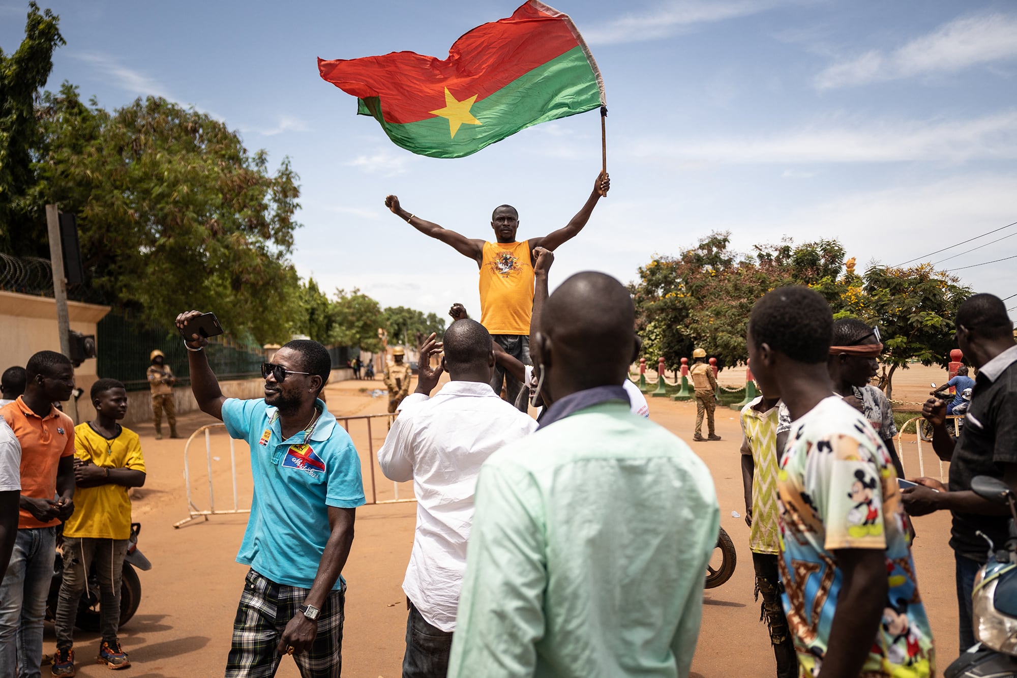 Un hombre flamea una bandera de Burkina Faso mientras militares ocupan posiciones en Ouagadougou horas antes del golpe de Estado.