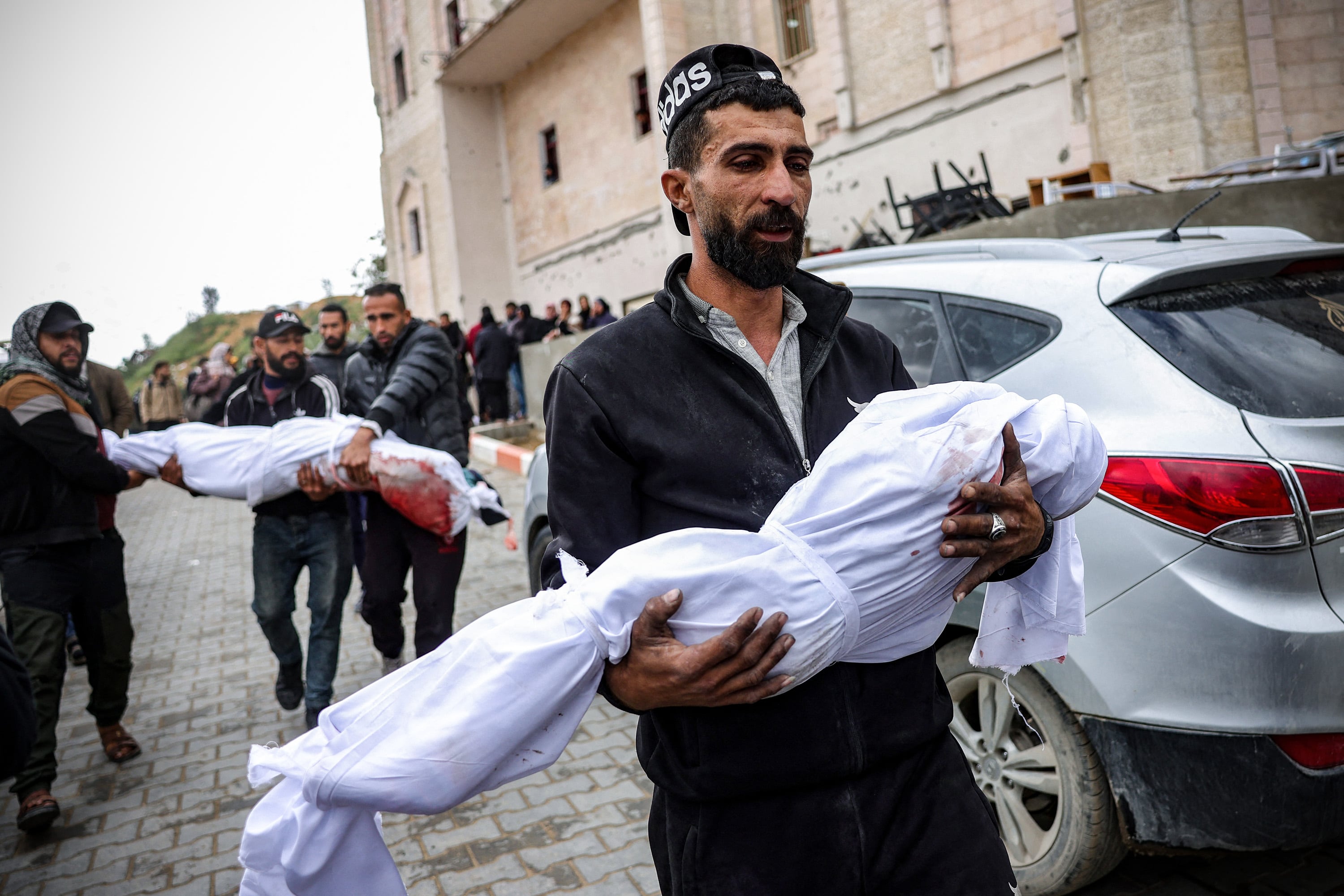 Hombres palestinos cargan los cuerpos de las víctimas en el norte de Gaza