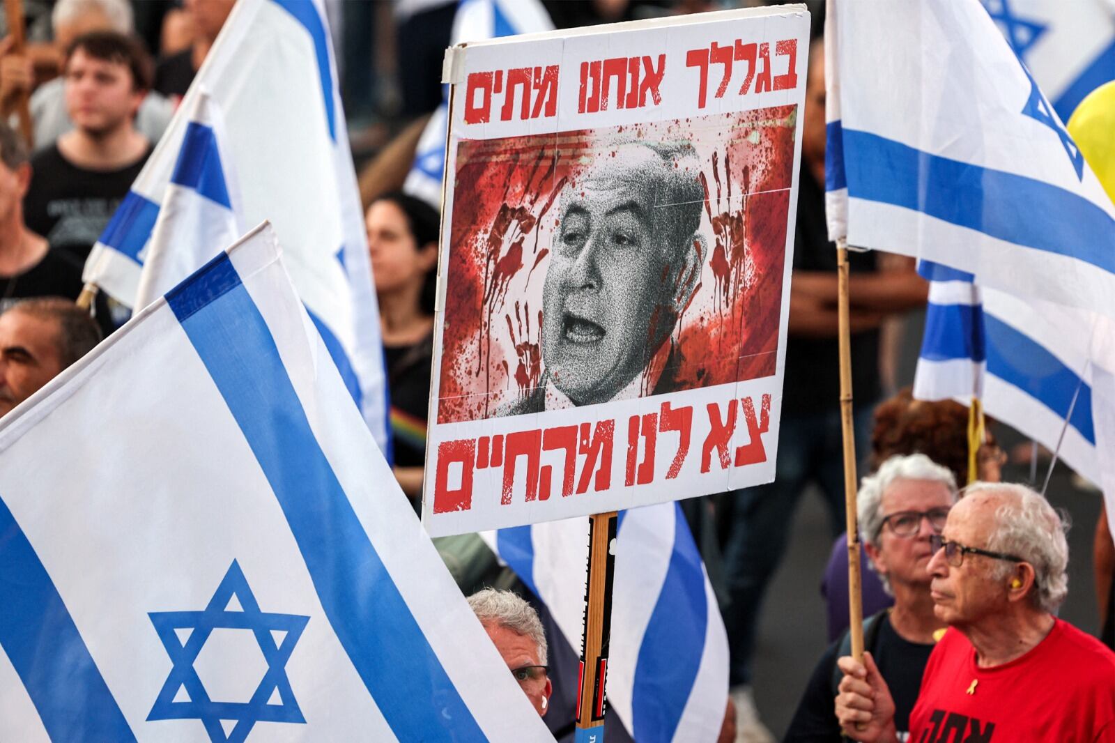 Un manifestante sostiene un cartel contra Netanyahu en Tel Aviv