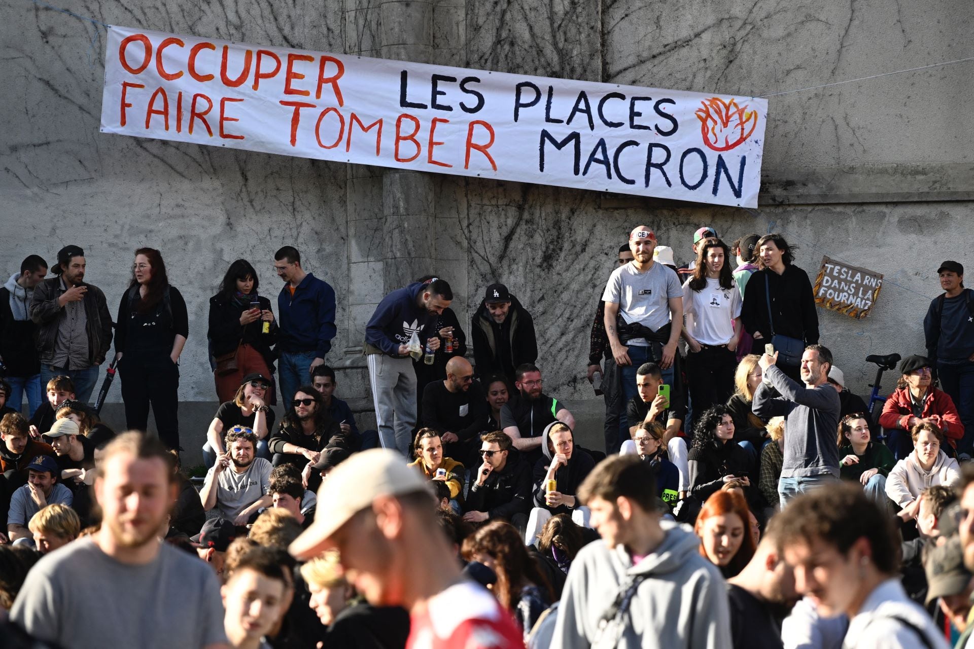 "Ocupar los lugares, derribar a Macron", reza el cartél desplegado en un edificio público en París. (Foto: AFP)