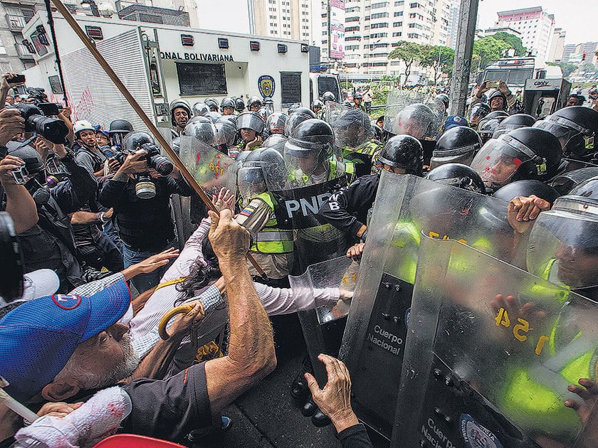 Policías reprimen ayer en Caracas una “marcha de los abuelos”.