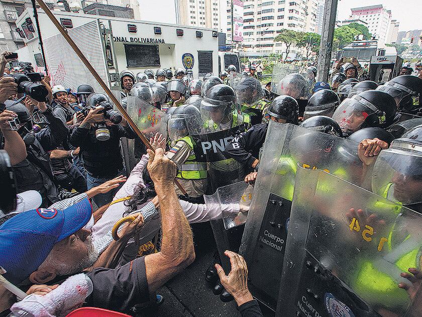 Policías reprimen ayer en Caracas una “marcha de los abuelos”.