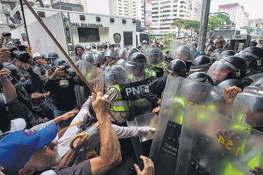 Policías reprimen ayer en Caracas una “marcha de los abuelos”.