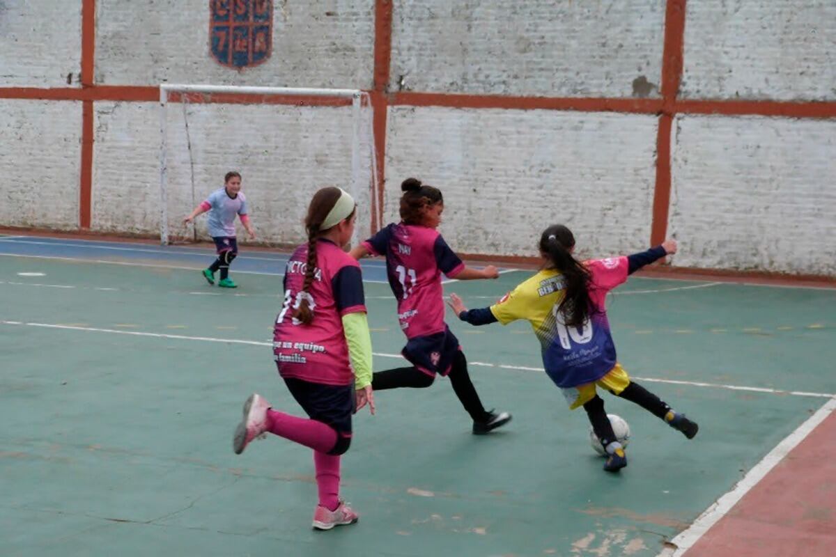 Niñas jugando al fútbol en un club de barrio.
