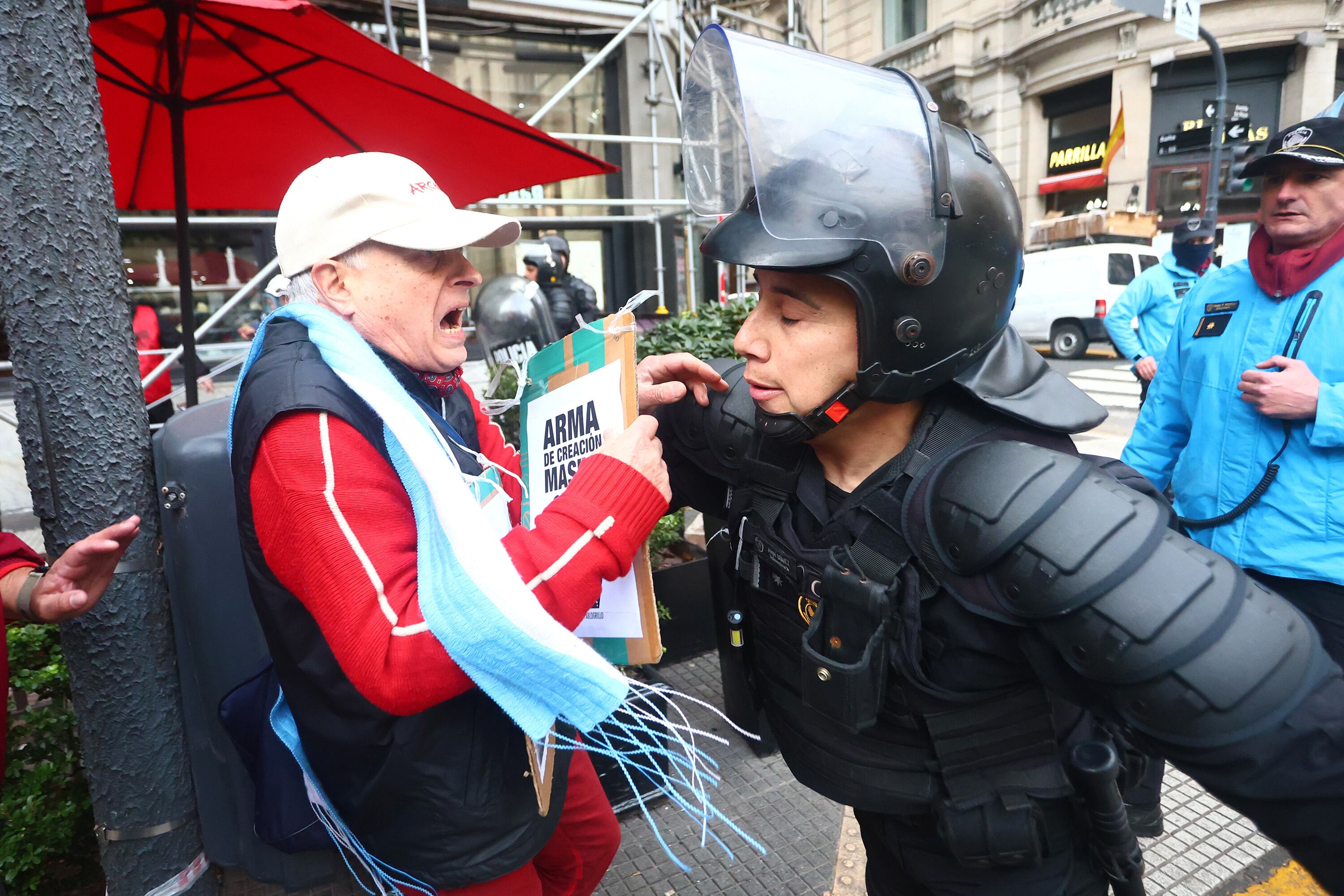 Un efectivo policial forcejea con un jubilado durante la marcha.