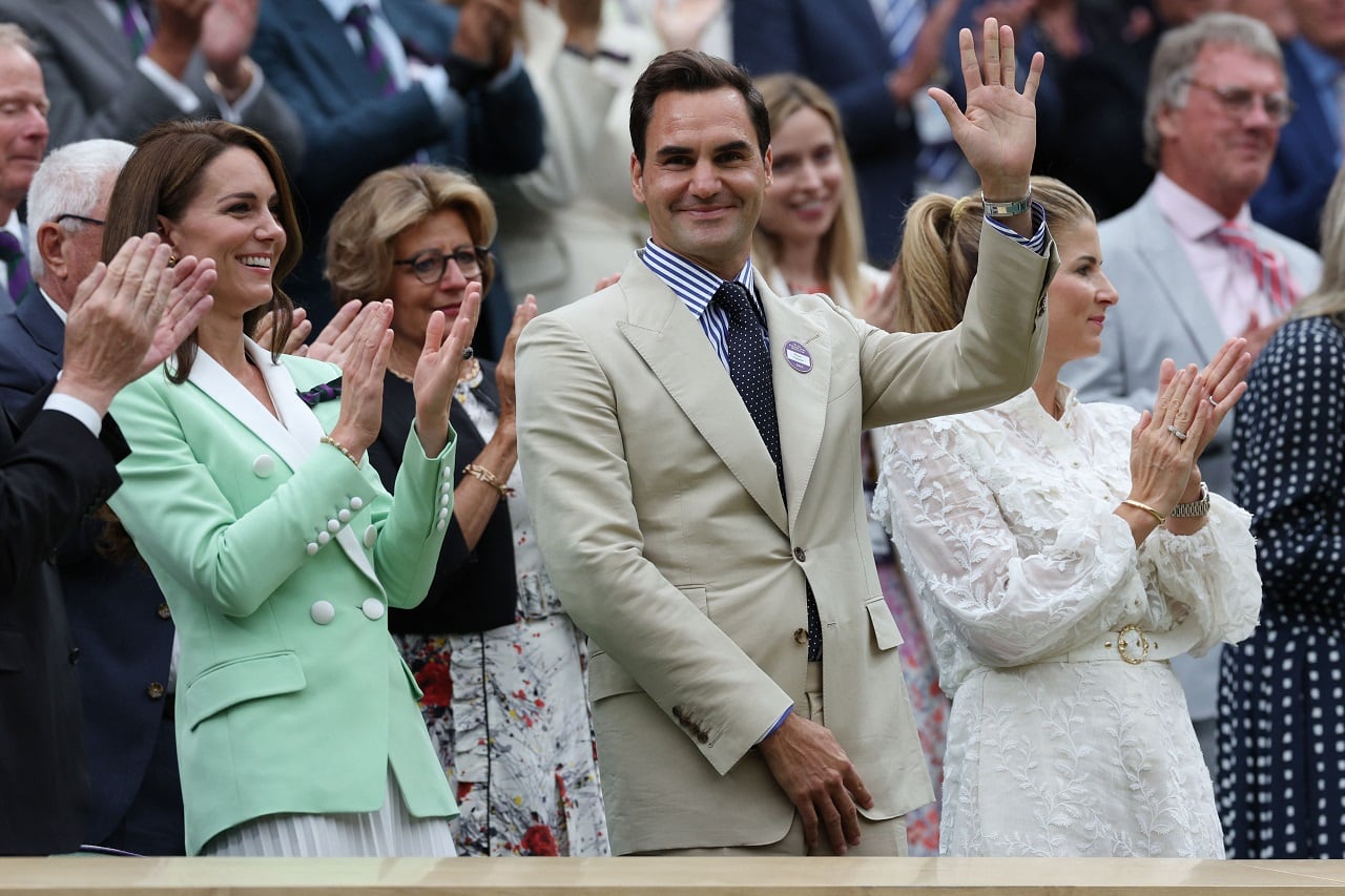 Roger Federer devuelve los aplausos con un saludo. A su derecha, la princesa Kate Middleton y, a su izquierda, su esposa Mirka