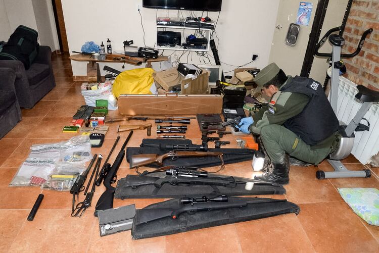 Un efectivo de Gendarmería junto a parte de las armas incautadas