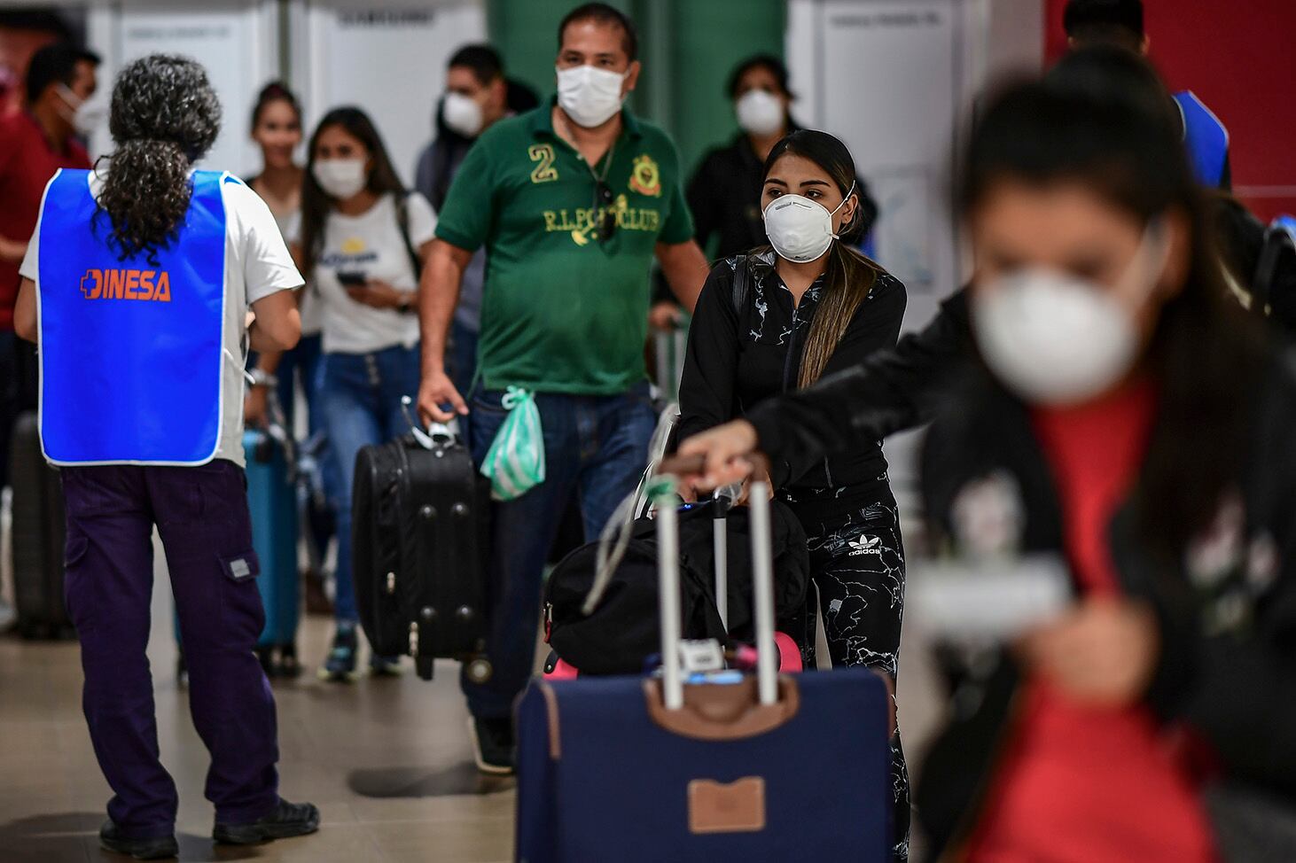 Pasajeros que llegan de países en riesgo, con barbijos en Ezeiza.