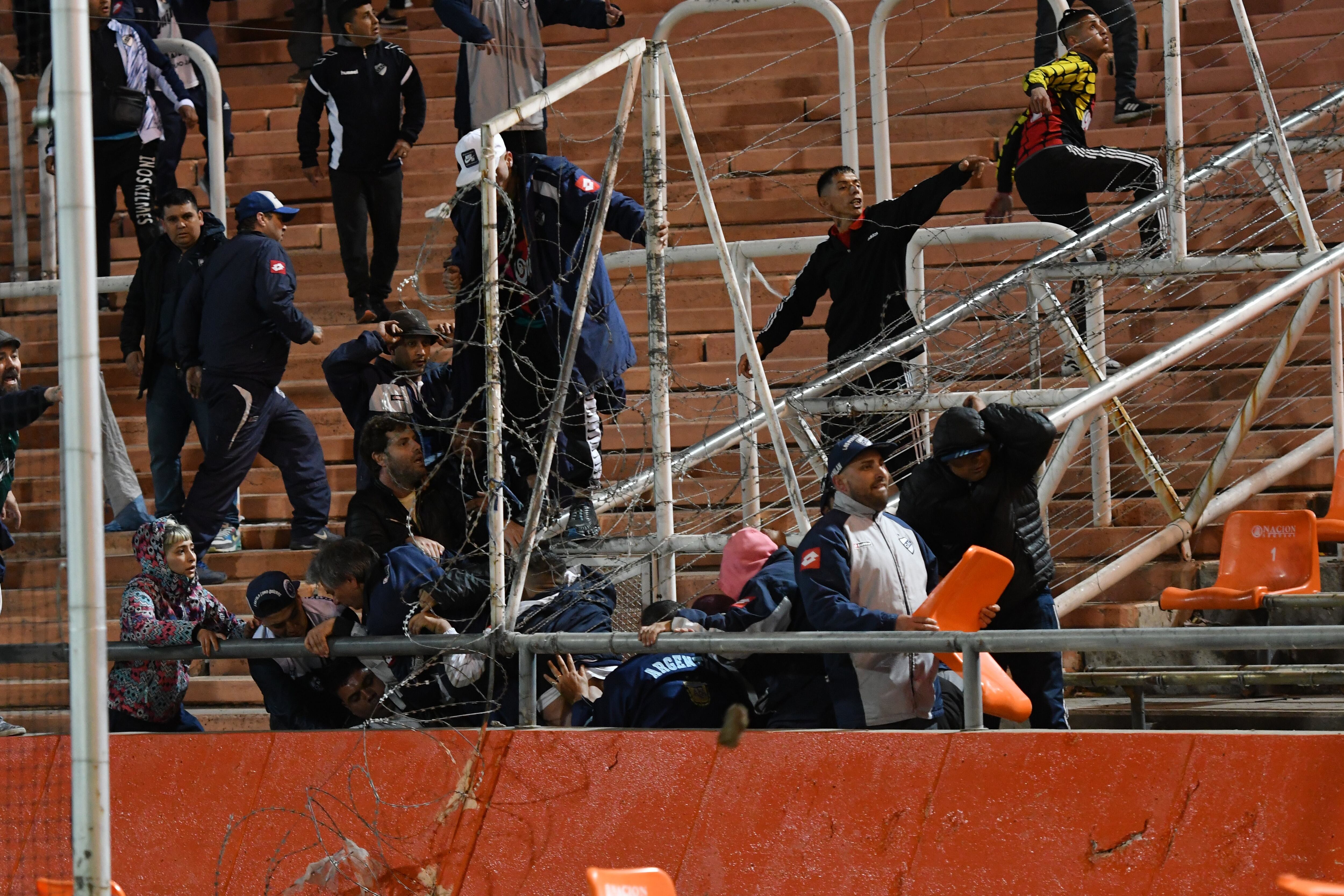 Un grupo de violentos de la parcialidad quilmeña lanzando piedras a los hinchas de Boca (Foto: Télam).