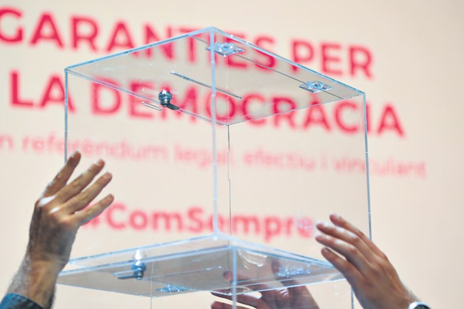 Diputados del Parlamento catalán sostienen una urna de vidrio durante la presentación.