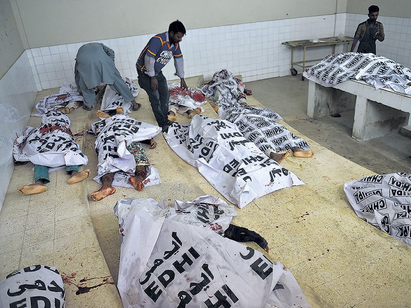 Voluntarios paquistaníes revisan los cadáveres de supuestos insurgentes abatidos ayer.