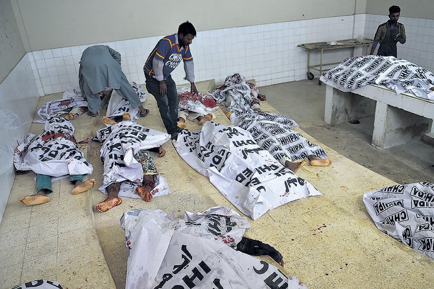 Voluntarios paquistaníes revisan los cadáveres de supuestos insurgentes abatidos ayer.