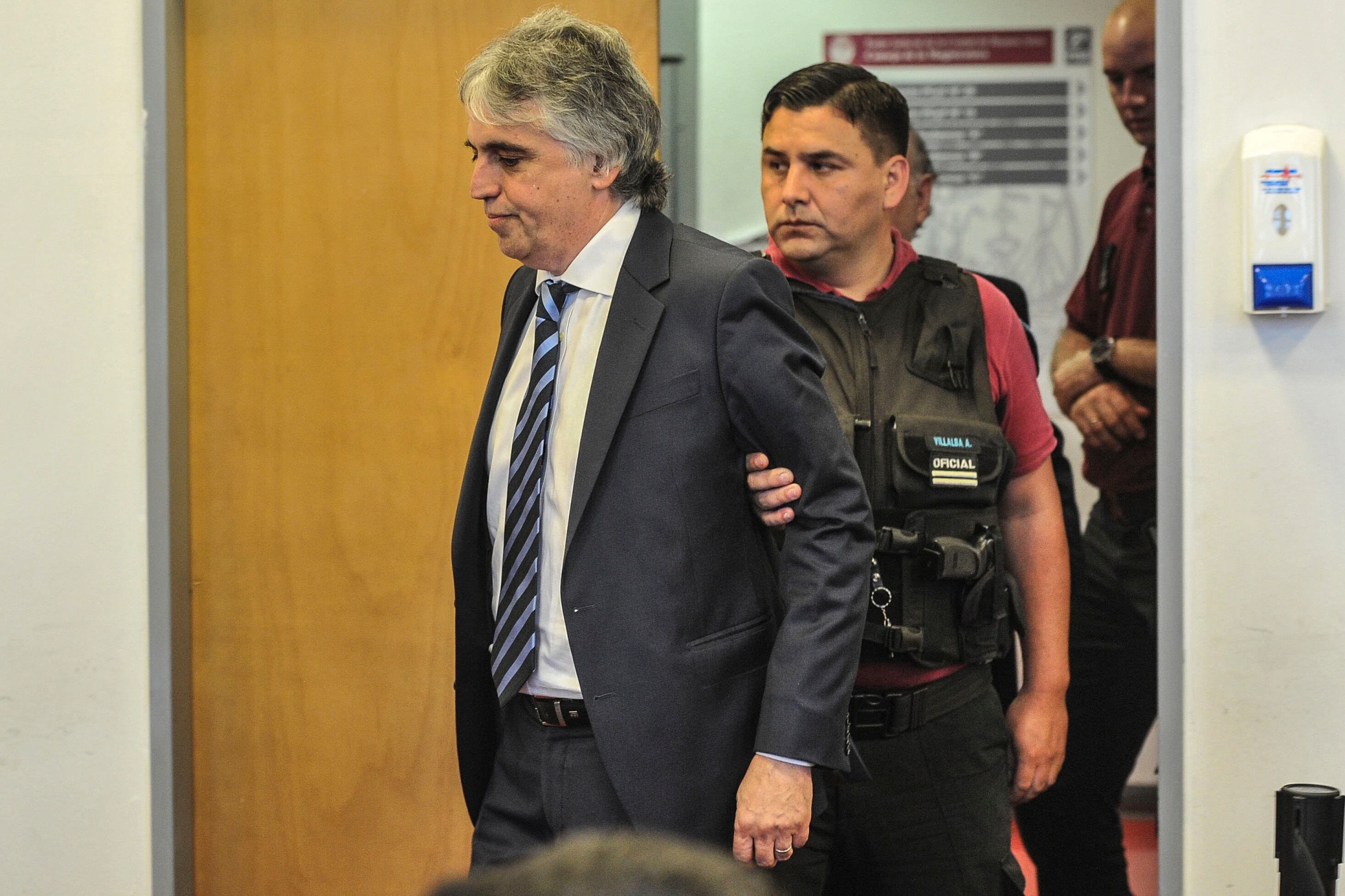 Ricardo Russo es trasladado por la policía al finalizar el juicio.
