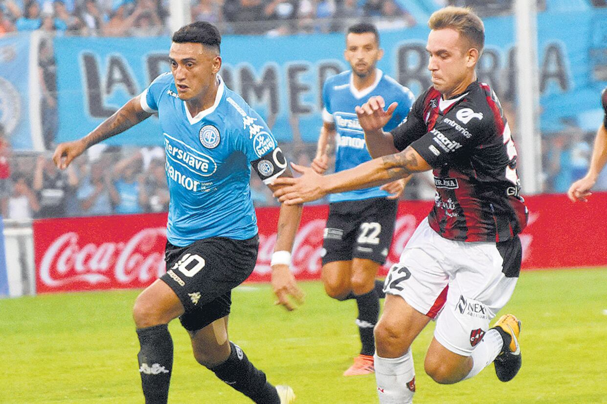 Matías Suárez lleva la pelota. Gil Romero intenta sacársela.