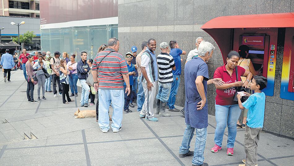 Venezolanos hacen cola en cajeros automáticos, donde pudieron sacar hasta 10 bolívares soberanos.