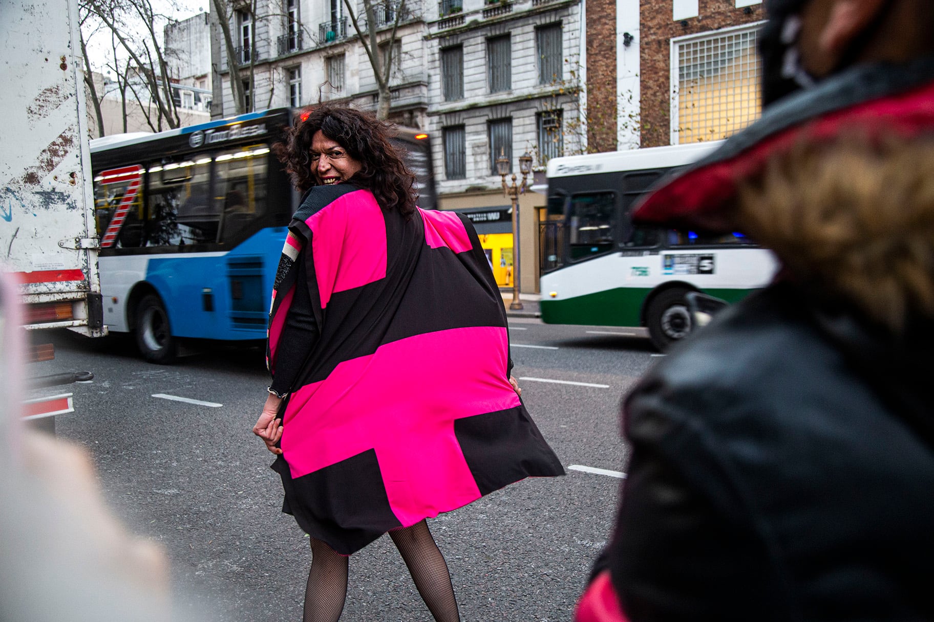 Marlene Wayar envuelta en la bandera travesti latinoamericana, diseñada por Alejandro Ros
